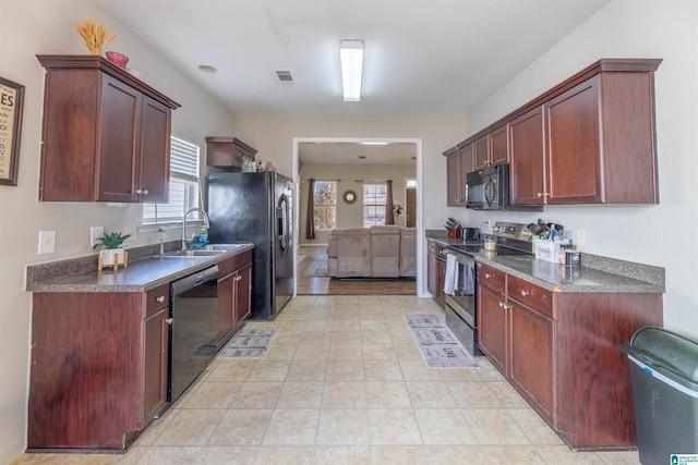 kitchen with visible vents, a sink, black appliances, dark brown cabinets, and dark countertops