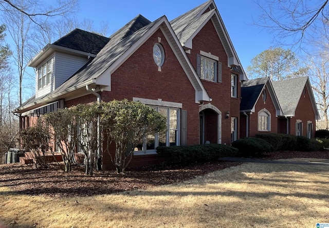 view of front of home with brick siding and a shingled roof