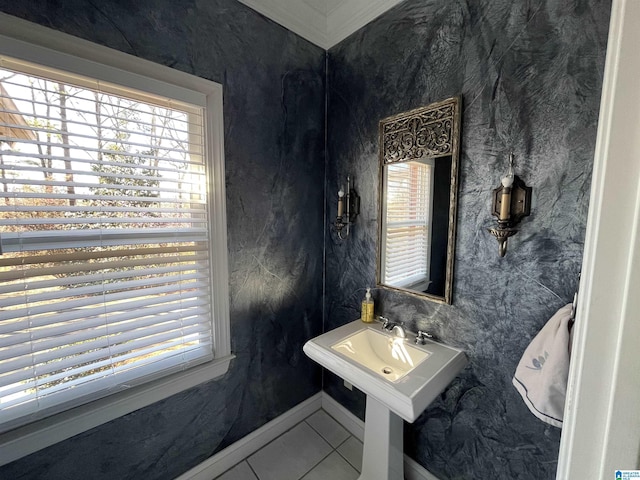 bathroom featuring tile patterned flooring, plenty of natural light, baseboards, and a sink