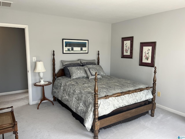 bedroom featuring baseboards, visible vents, and light carpet