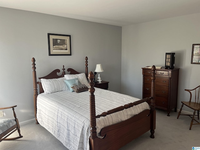 bedroom with light colored carpet and baseboards