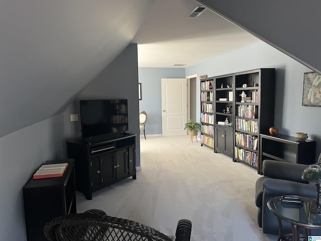 sitting room with visible vents, carpet, and lofted ceiling