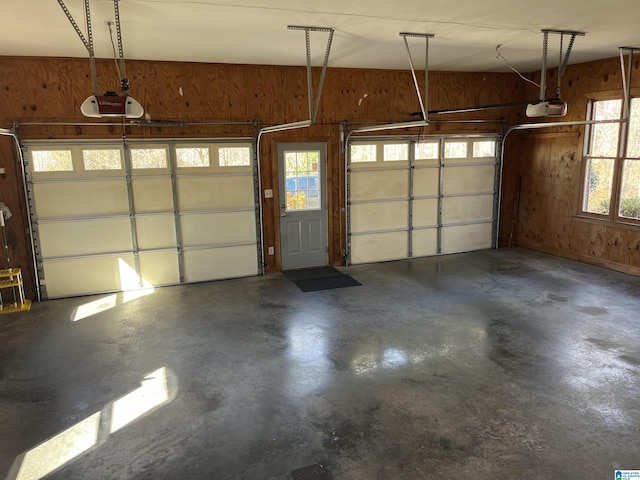 garage featuring a garage door opener and wood walls