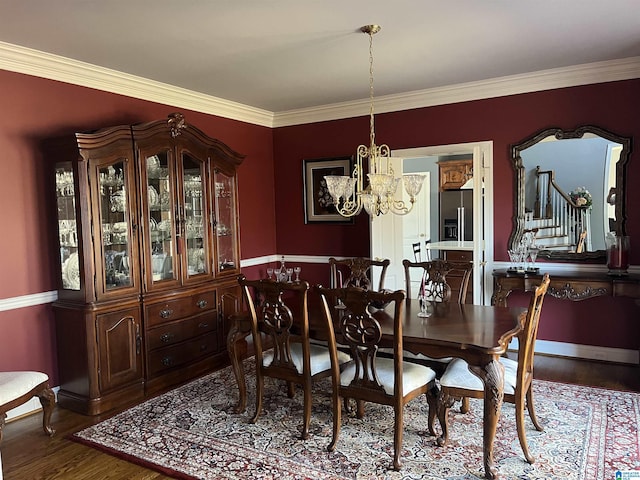 dining space featuring stairs, crown molding, wood finished floors, and a chandelier