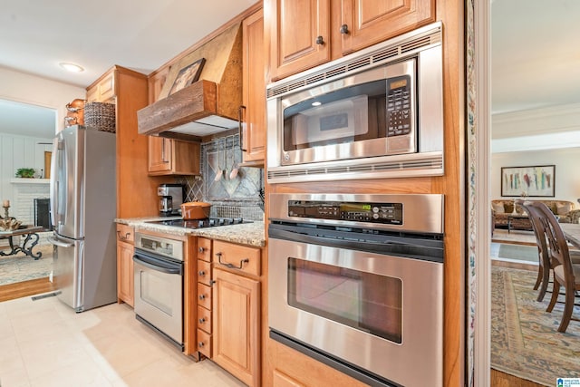 kitchen with light stone countertops, light tile patterned flooring, ornamental molding, appliances with stainless steel finishes, and tasteful backsplash