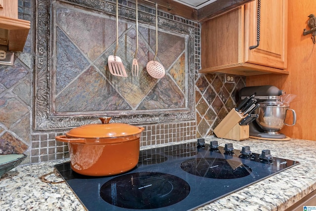 interior details with backsplash and black electric stovetop