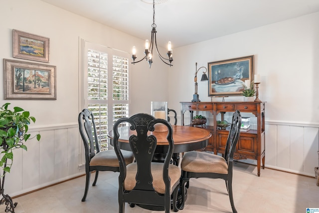 dining space with an inviting chandelier and wainscoting