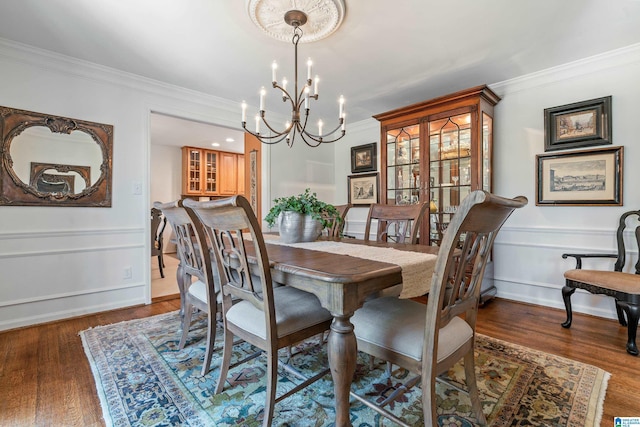 dining room featuring a chandelier, crown molding, and wood finished floors