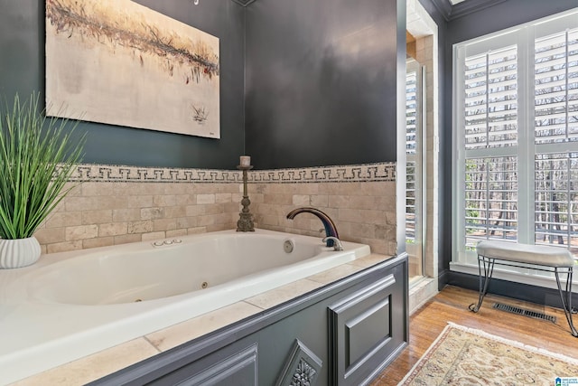 full bathroom with visible vents, wood finished floors, and a whirlpool tub