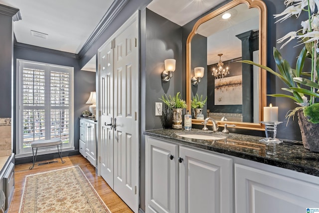 bathroom with vanity, wood finished floors, and ornamental molding