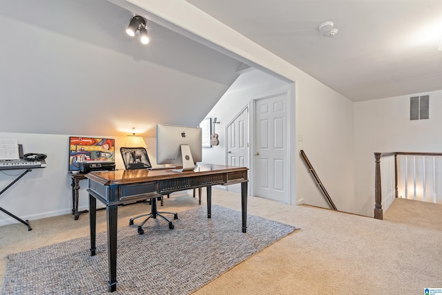 carpeted home office with lofted ceiling, baseboards, and visible vents