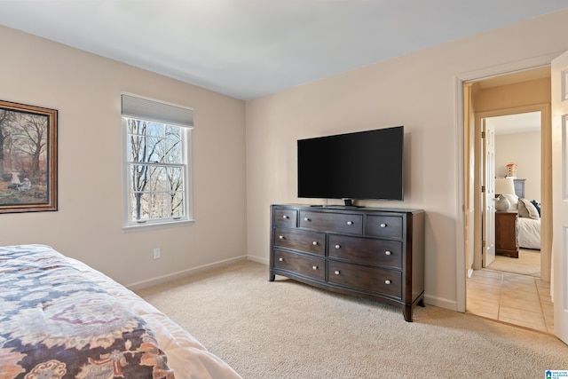 bedroom featuring light colored carpet and baseboards