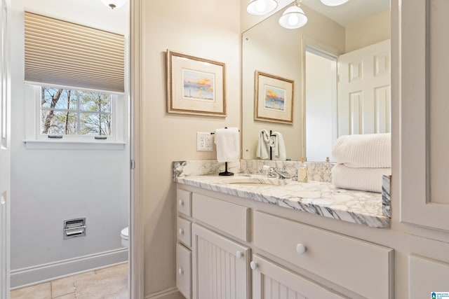 bathroom featuring vanity, toilet, and baseboards