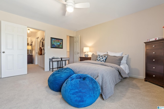 bedroom featuring baseboards, light colored carpet, and ceiling fan