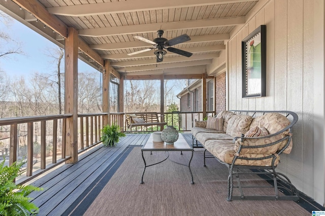 unfurnished sunroom featuring beam ceiling, wooden ceiling, and ceiling fan