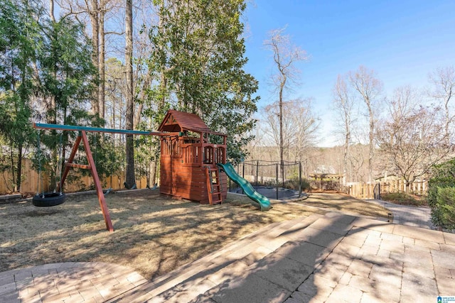 view of jungle gym with a trampoline and fence