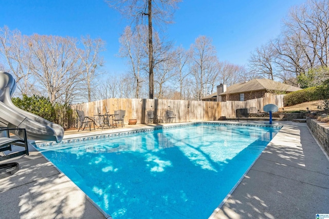 view of pool with a fenced in pool, a patio, a water slide, and a fenced backyard