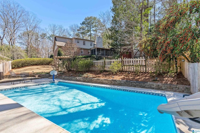 view of swimming pool with a fenced in pool, a patio, a water slide, and a fenced backyard