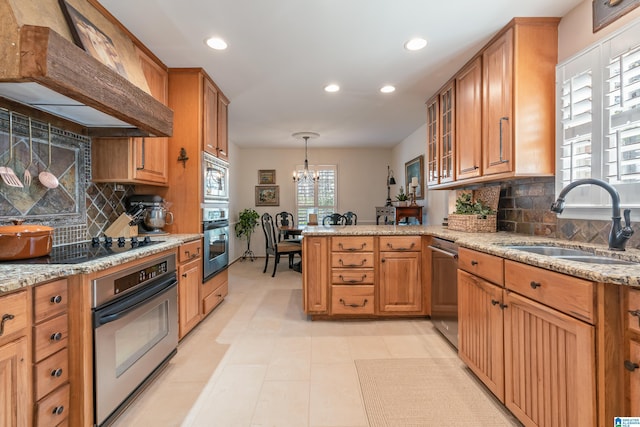 kitchen featuring custom exhaust hood, an inviting chandelier, a peninsula, a sink, and stainless steel appliances