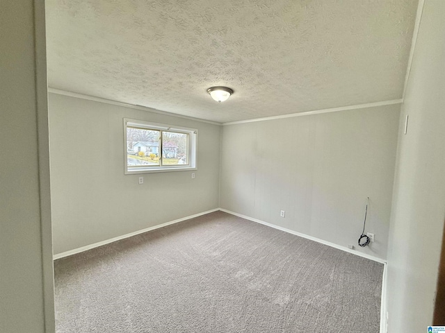 carpeted empty room featuring baseboards, a textured ceiling, and ornamental molding