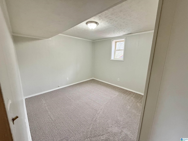 interior space featuring carpet flooring, a textured ceiling, crown molding, and baseboards