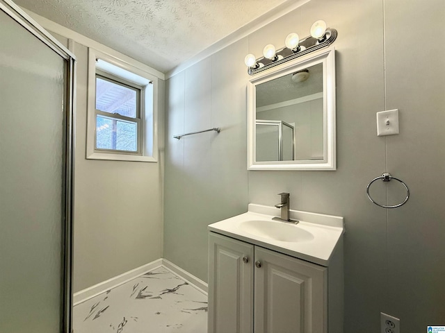 bathroom featuring vanity, a shower with shower door, baseboards, a textured ceiling, and marble finish floor