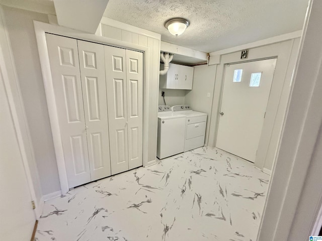 laundry area with baseboards, cabinet space, a textured ceiling, marble finish floor, and washer and clothes dryer