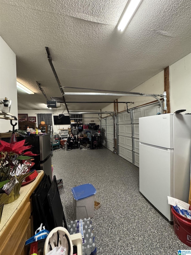 garage with a garage door opener and freestanding refrigerator