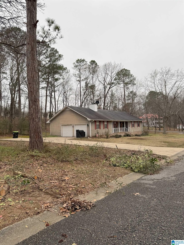 view of front of house featuring a porch, driveway, and an attached garage