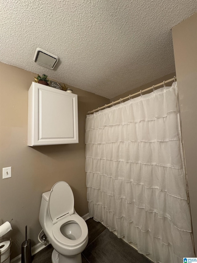 bathroom featuring visible vents, a shower with curtain, a textured ceiling, and toilet