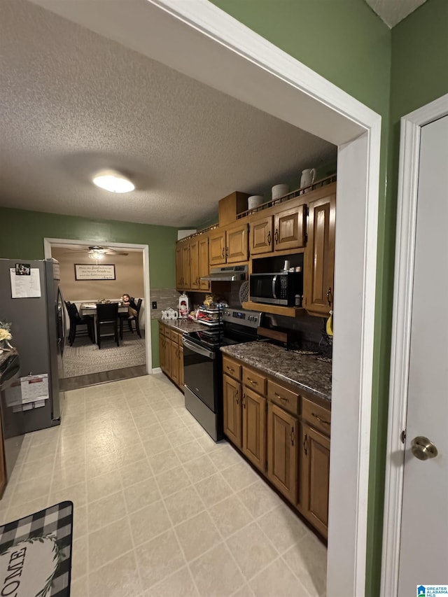 kitchen with brown cabinets, appliances with stainless steel finishes, and a textured ceiling