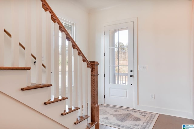 entrance foyer with stairs, wood finished floors, and baseboards