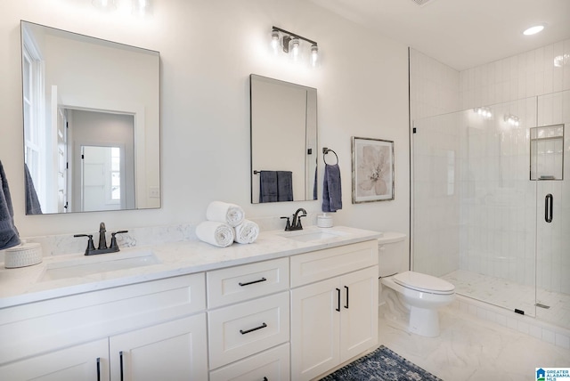 bathroom with marble finish floor, toilet, a shower stall, and a sink