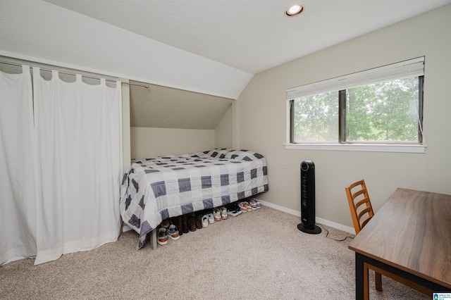 bedroom featuring a textured ceiling, baseboards, carpet, and lofted ceiling