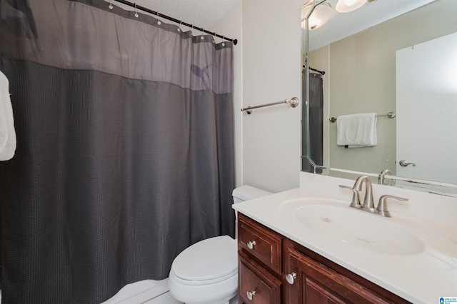 full bathroom featuring a shower with shower curtain, toilet, vanity, and a textured ceiling