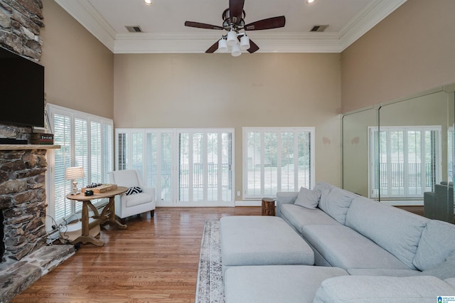 living area with visible vents, a fireplace, and ornamental molding