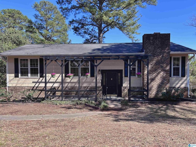 view of front of house with brick siding and a chimney