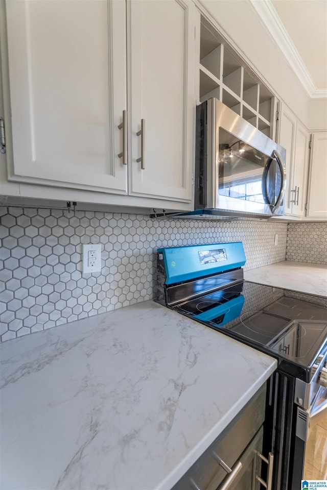 kitchen featuring crown molding, backsplash, light stone countertops, and appliances with stainless steel finishes