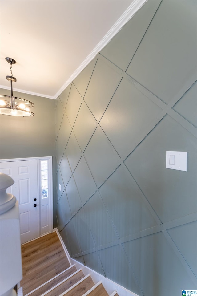 foyer with crown molding and wood finished floors