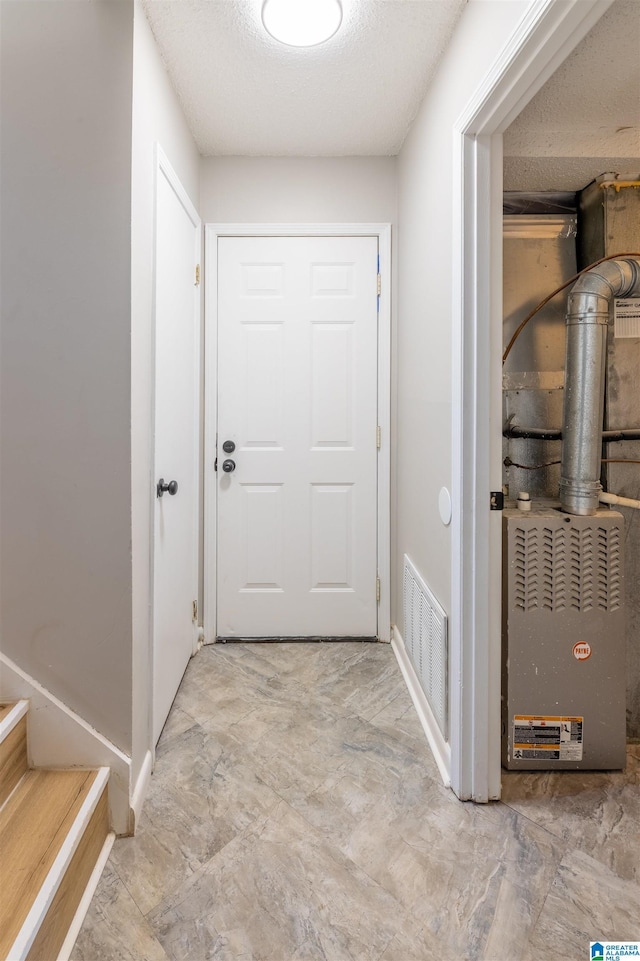 hallway featuring stairs, visible vents, and a textured ceiling