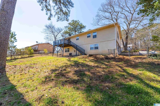 back of house with stairway, a yard, and fence