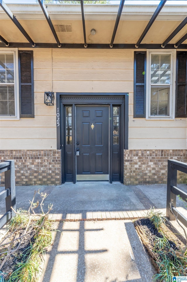 entrance to property featuring brick siding