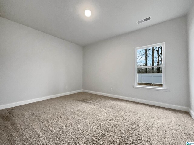 unfurnished room featuring visible vents, baseboards, and carpet