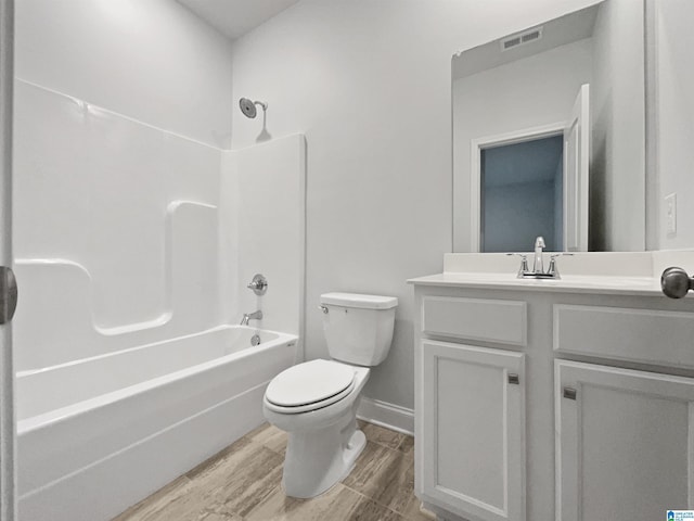 bathroom featuring vanity, wood finished floors, visible vents, shower / tub combination, and toilet