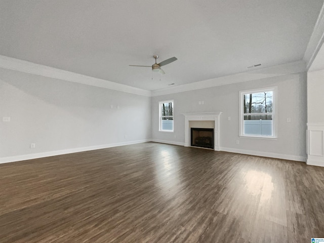 unfurnished living room with a ceiling fan, dark wood finished floors, a fireplace, and crown molding