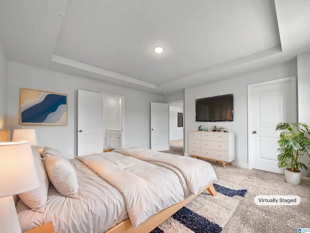 bedroom with a raised ceiling, light colored carpet, and baseboards