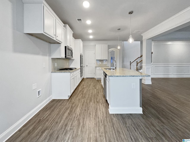 kitchen featuring visible vents, a sink, arched walkways, appliances with stainless steel finishes, and white cabinets