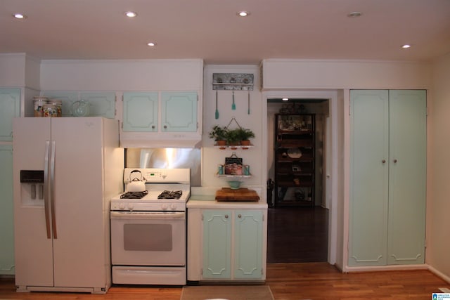 kitchen featuring under cabinet range hood, white appliances, light wood-style flooring, and recessed lighting