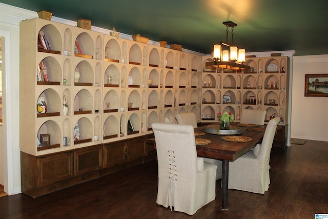 wine area featuring a chandelier, crown molding, and dark wood-style flooring