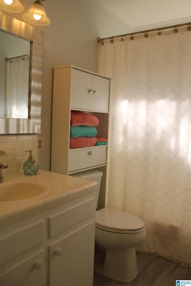 full bathroom featuring vanity, wood finished floors, curtained shower, toilet, and backsplash